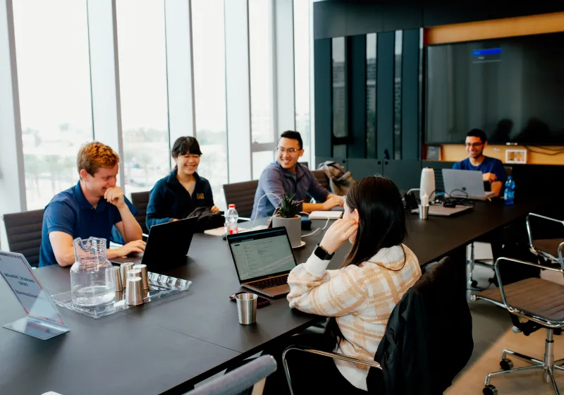 people laughing around a meeting room table
