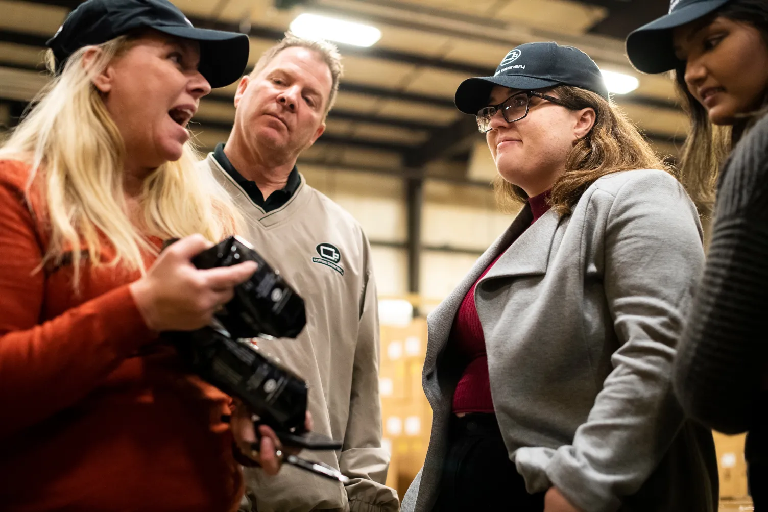 a group of people talking about equipment that one of the people is holding